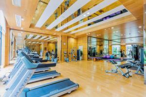 a gym with several treadmills and exercise machines at Ramada By Wyndham Huizhou South in Huizhou