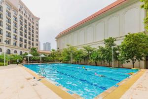 a large swimming pool in front of a building at Ramada By Wyndham Huizhou South in Huizhou