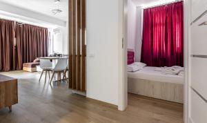 a bedroom with a bed and a table in a room at SnS Apartament Regal in Mamaia +10 photos