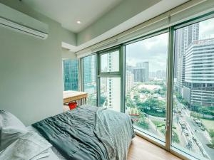 - une chambre avec un lit et une grande fenêtre dans l'établissement Vibrant Oasis with the best view + Fast WiFi, à Manille