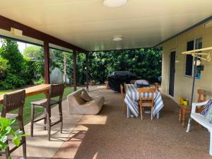 a covered patio with a table and chairs and a table and chairsktop at Keppel Cottage - 7 Limpus Avenue Keppel Sands in Keppel Sands