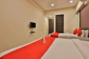 a hotel room with a bed and a television at Hotel Royal Rituals Vesu in Surat