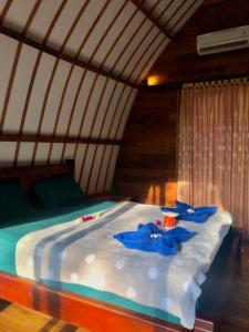 a large bed in a tent with blue clothes on it at Blue Moon Meno in Gili Meno