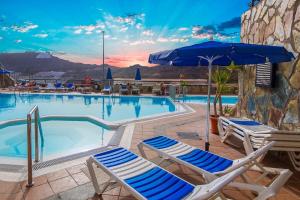 uma piscina com espreguiçadeiras e um guarda-sol em Apartment With Jacuzzi and pool access em Puerto Rico de Gran Canaria