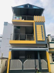 un bâtiment jaune avec un balcon. dans l'établissement Fourseason frankcottage, à Chikmagalur