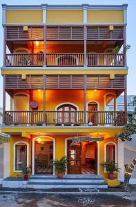 un gran edificio amarillo con balcones. en VILLA DU OCEAN en Pondicherry