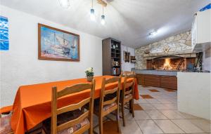 a dining room with a table and a fireplace at Cozy Home In Slivnica in Slivnica