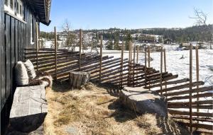 a fence next to a building with a snowy field at Nice Home In Veggli With Wifi in Veggli +14 photos