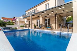 a swimming pool in front of a house at Villa Renesansa in Milna