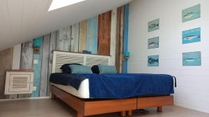 een slaapkamer met een bed met een blauw dekbed bij Atypical luxury 2 bedrooms house Saint Colomban beaches and shops on foot in Carnac