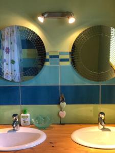 two sinks in a bathroom with two mirrors at Comme à la maison à la montagne in Briançon