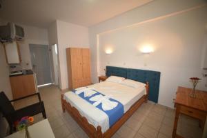 1 dormitorio con 1 cama con toallas en Anaxos Bay Rooms & Apartments, en Anaxos