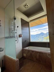 un bagno con vasca e una grande finestra di Dragon Manor Resort a Ren'ai