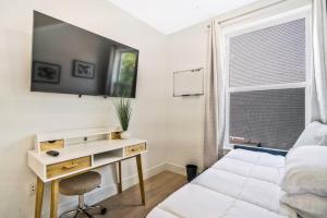 a bedroom with a desk and a bed and a window at Luxurious and stylish 2 bedroom 2 bathroom suite in Washington, D.C.