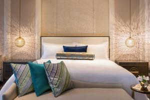 a bedroom with a large white bed with blue pillows at The St. Regis Langkawi in Kuah