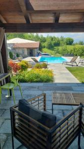 eine Terrasse mit 2 Bänken und einem Pool in der Unterkunft Ca' del magu in San Michele Mondovì