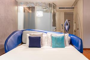 a blue and white bed with pillows on it at Hotel Baraquda Heeton Pattaya by Compass Hospitality in Pattaya