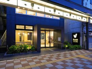 un bâtiment avec un panneau sur son côté dans l'établissement Far East Village Hotel Tokyo, Asakusa, à Tokyo