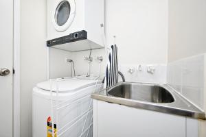 una piccola cucina con lavandino e lavatrice di Mooloolaba 1 BR Getaway - Perfect location ZD5 a Mooloolaba