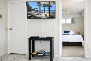 una camera con un letto e un tavolo con una foto sul muro di Mooloolaba 1 BR Getaway - Perfect location ZD5 a Mooloolaba