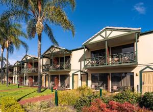 a building with palm trees in front of it at Hotel Renmark in Renmark