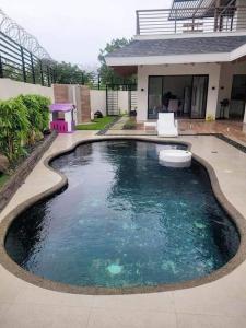 a swimming pool in front of a house at Lux 7 Pool Villa Mactan in Mactan