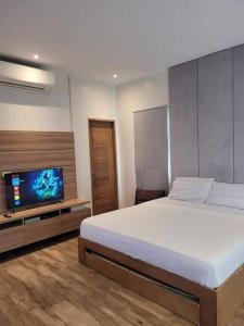 a bedroom with a bed and a flat screen tv at Lux 7 Pool Villa Mactan in Mactan