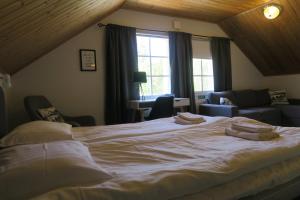 a bedroom with a large white bed with pillows on it at Marjoniemi Camping in Hiidenniemi
