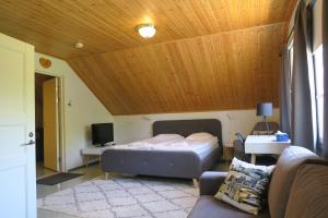 a bedroom with a bed and a couch in a room at Marjoniemi Camping in Hiidenniemi