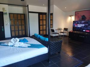 1 dormitorio con 1 cama y TV de pantalla plana en The Venue Residence - SHA Extra Plus en Pattaya South