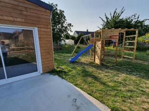 a playground next to a house with a slide at Le Mont comme à la maison in Roz-sur-Couesnon