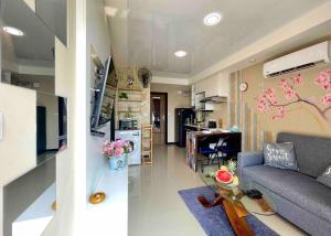a living room with a couch and a kitchen at NEW one bedroom apartment MBC E in Ban Bo Sai Klang