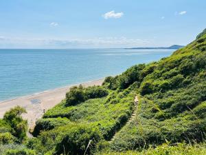 a view of a beach with the ocean in the background at Kinetic Stays - Serenity Holiday Cottages in Sidmouth