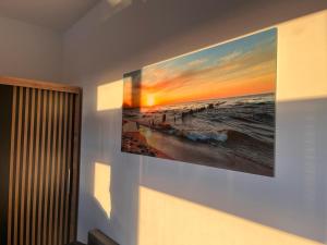 a painting of the ocean on a wall at Słoneczne Apartamenty in Ustronie Morskie