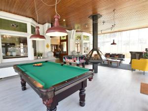a billiard room with a pool table and a fireplace at Former hotel in the centre and at 50 metres from the beach in Panne in De Panne