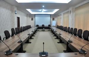 a conference room with chairs and a large screen at OASE GUEST HOUSE in Medan