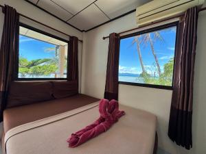 a bed in a room with a large window at Phangan Lodge in Ban Tai