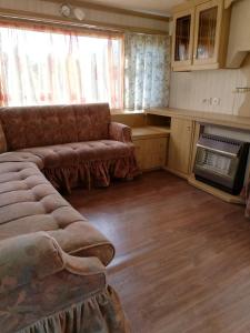 sala de estar con sofá y cocina en Kempings Mežmalas, en Usma