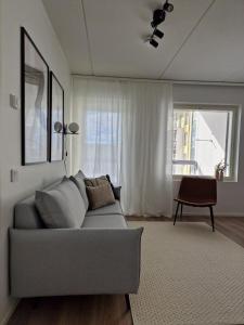 a living room with a gray couch and a window at Huhta Sport in Jyväskylä