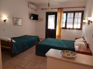 a hotel room with two beds and a table at PORTO KATSIKI-HOME in Athani