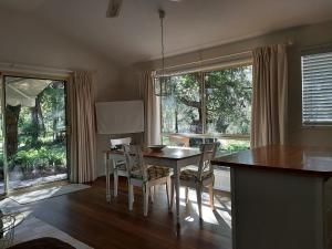 a dining room with a table and chairs and windows at Wondai Hideaway Apartment in Wondai
