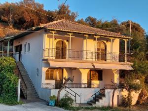 a yellow house with a balcony and a staircase at PORTO KATSIKI-HOME in Athanion