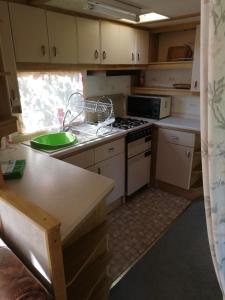 a kitchen with a sink and a stove top oven at Kempings Mežmalas in Usma