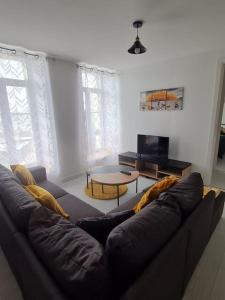 uma sala de estar com um sofá e uma mesa em l'annexe des Remparts em Rocroi