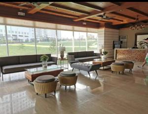 大雅台Condo Unit at Cool Suites SMDC Wind Tagaytay的一间配有沙发、桌子和窗户的大客厅