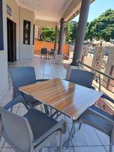 a wooden table and chairs on a patio at Franque Lodge in Durban