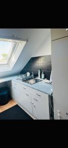 a kitchen with a sink and a counter with a window at Pension Rüge in Frankfurt