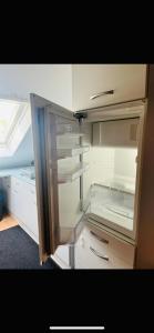 an empty refrigerator with its door open in a room at Pension Rüge in Frankfurt