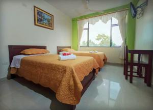 1 dormitorio con 2 camas y ventana en Imperio Amazonico, en Puyo