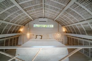 a large bed in a room with a ceiling at Gravity Eco Boutique Hotel - Adults Only in Uluwatu